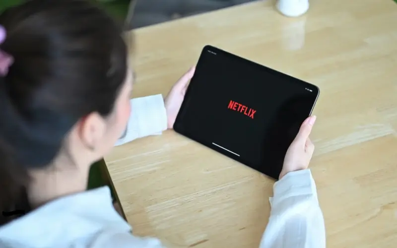 Person selecting content on a tablet, symbolizing customizable à la carte sponsorship choices.