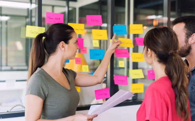 Event organizers collaborating on planning a virtual education fair, mapping out goals and timelines before execution.