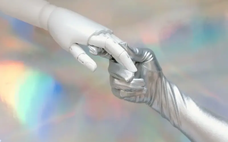 A robotic hand and a human hand reaching toward each other, symbolizing AI working alongside humans to support, enhance, and streamline event workflows.