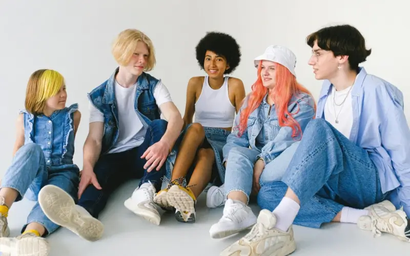 Teens sitting together and chatting casually, representing personal interest icebreaker questions for teens about hobbies, preferences, and everyday activities.