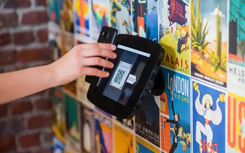 Close-up of a smartphone scanning a QR code displayed at a booth, representing paper-free follow-up at a career fair