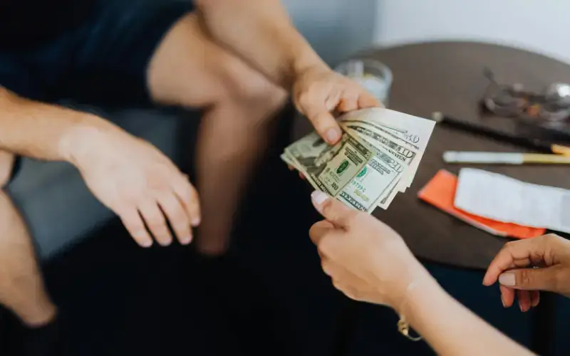 Hands counting cash to represent valuing sponsorship assets and pricing event sponsorship levels.