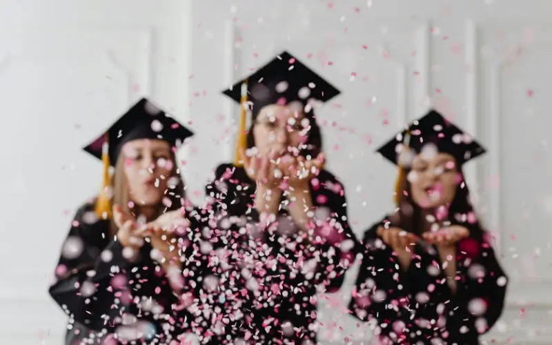 College graduates celebrating, representing students accessing career opportunities through university services.