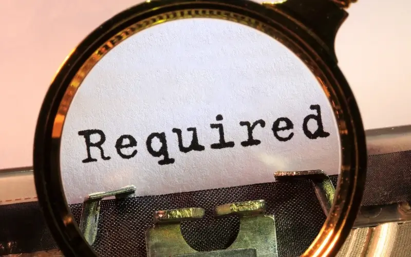 Magnifying glass highlighting the word ‘Required,’ representing mandatory ADA digital accessibility compliance.