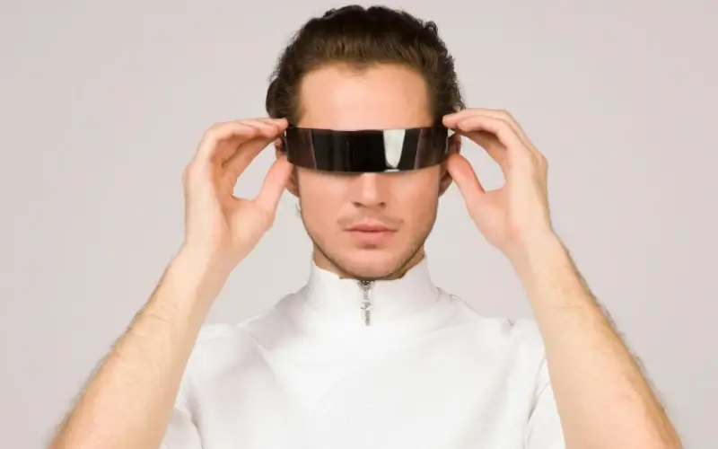 Person adjusting futuristic AR glasses, representing accessible and lightweight extended reality tools for modern live events.
