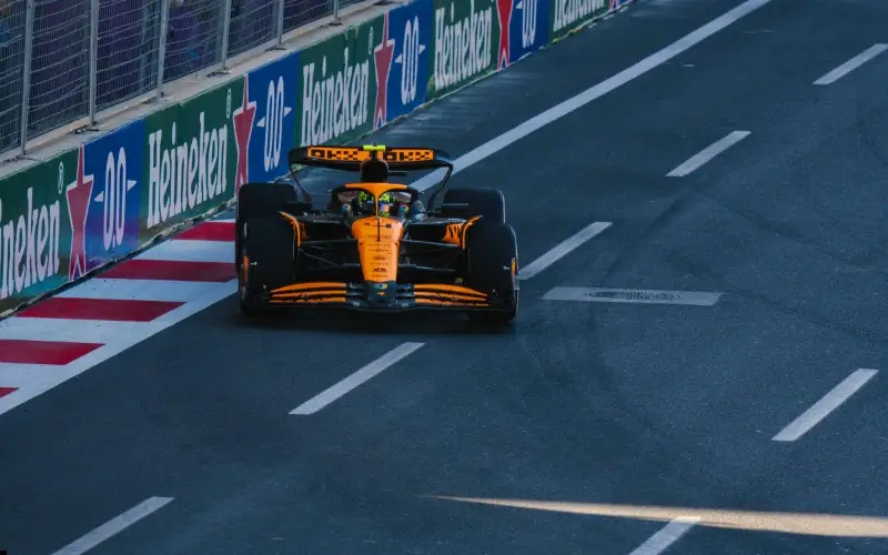 A Formula 1 car racing past trackside branding illustrates how event sponsorship integrates brand visibility into high-impact, live experiences.