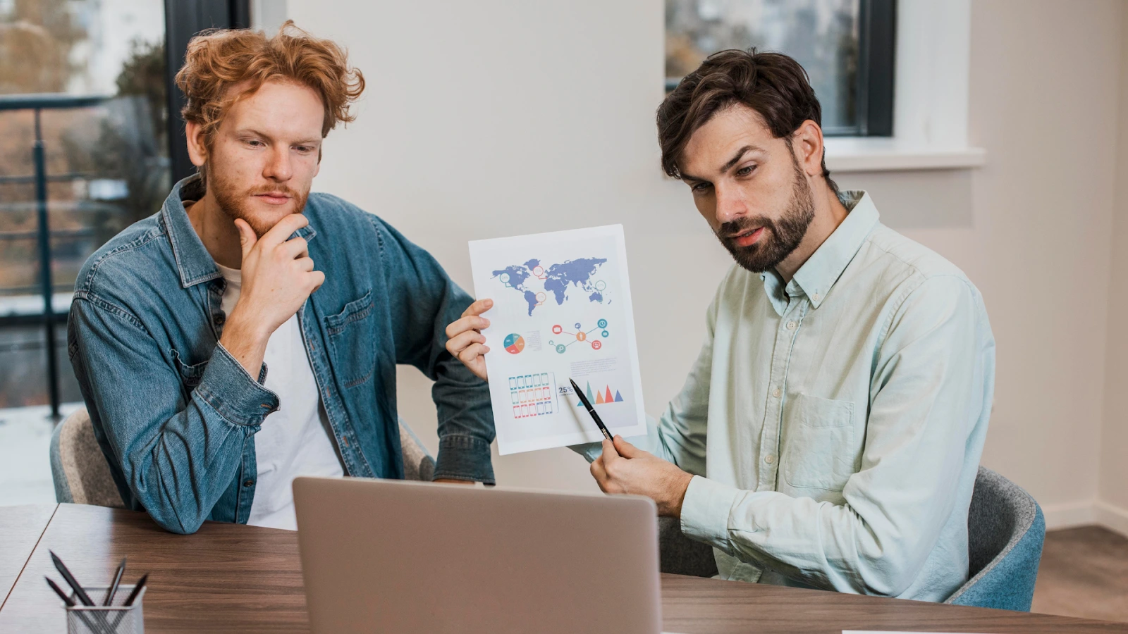 Team reviewing event sponsorship proposal and marketing data on a chart.