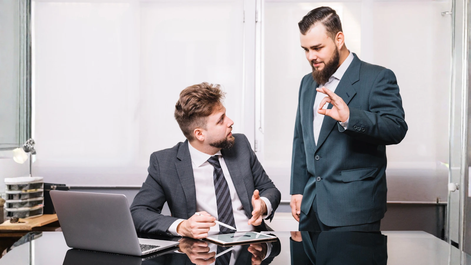 Two business professionals discussing event sponsorship strategy at an office desk.