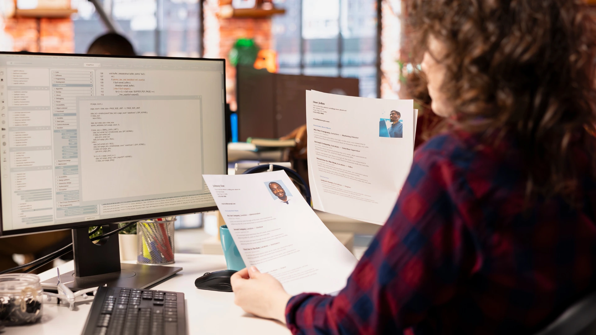Recruiter reviewing resumes at a virtual career fair resume feedback station.