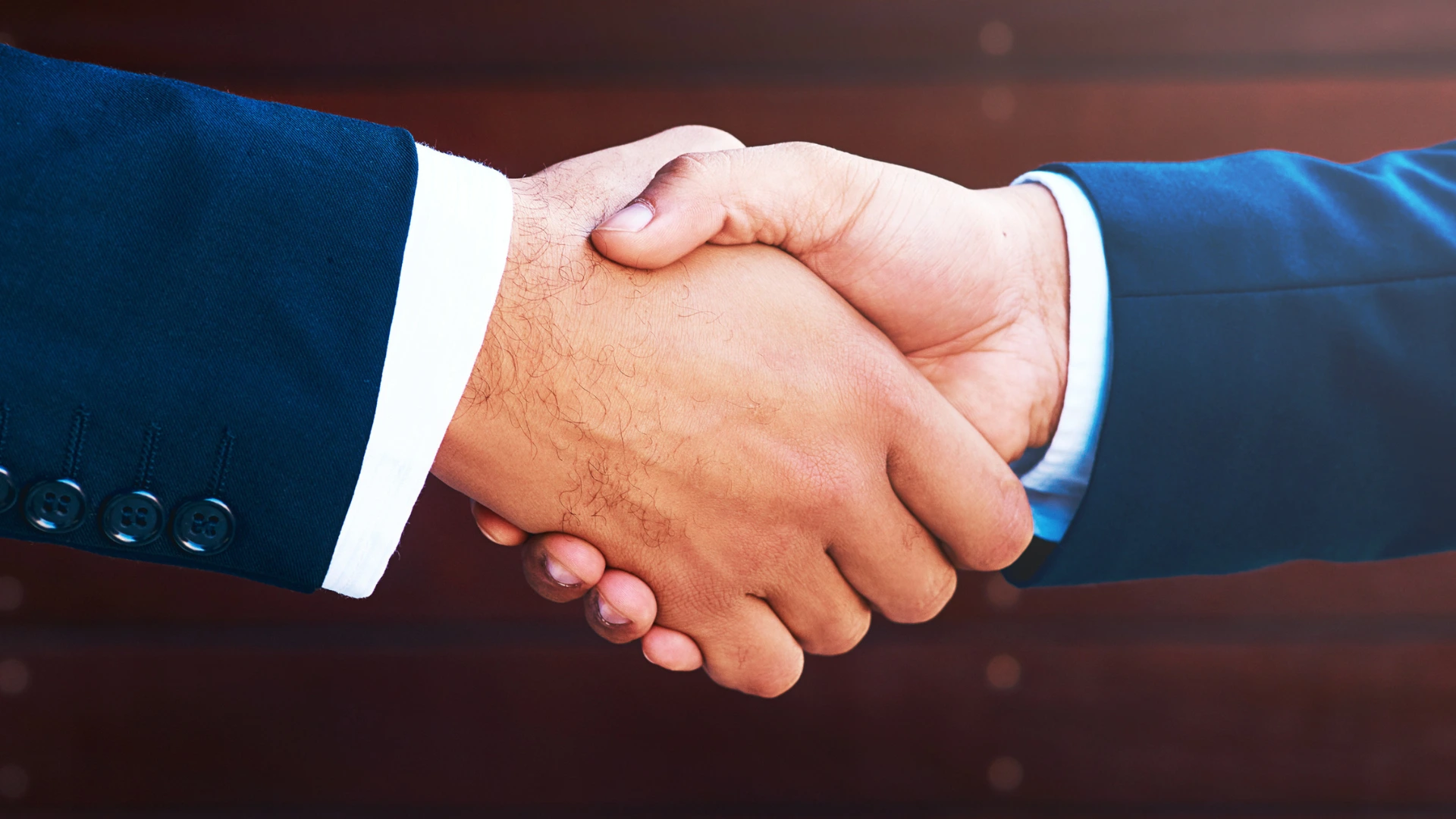 Handshake agreement between sponsor and event organizer partnership.