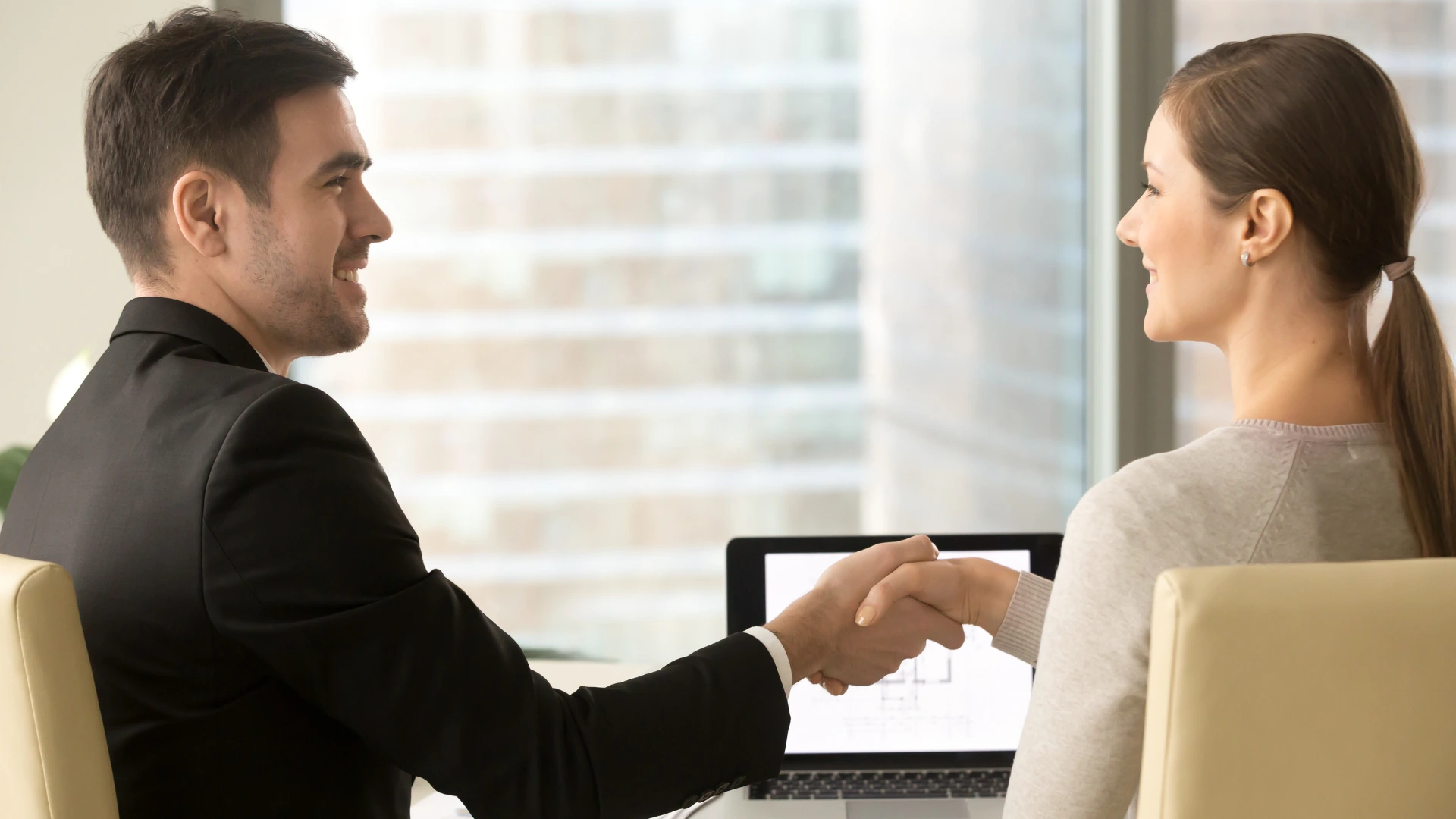 Student shaking hands with recruiter during a college career fair networking moment.