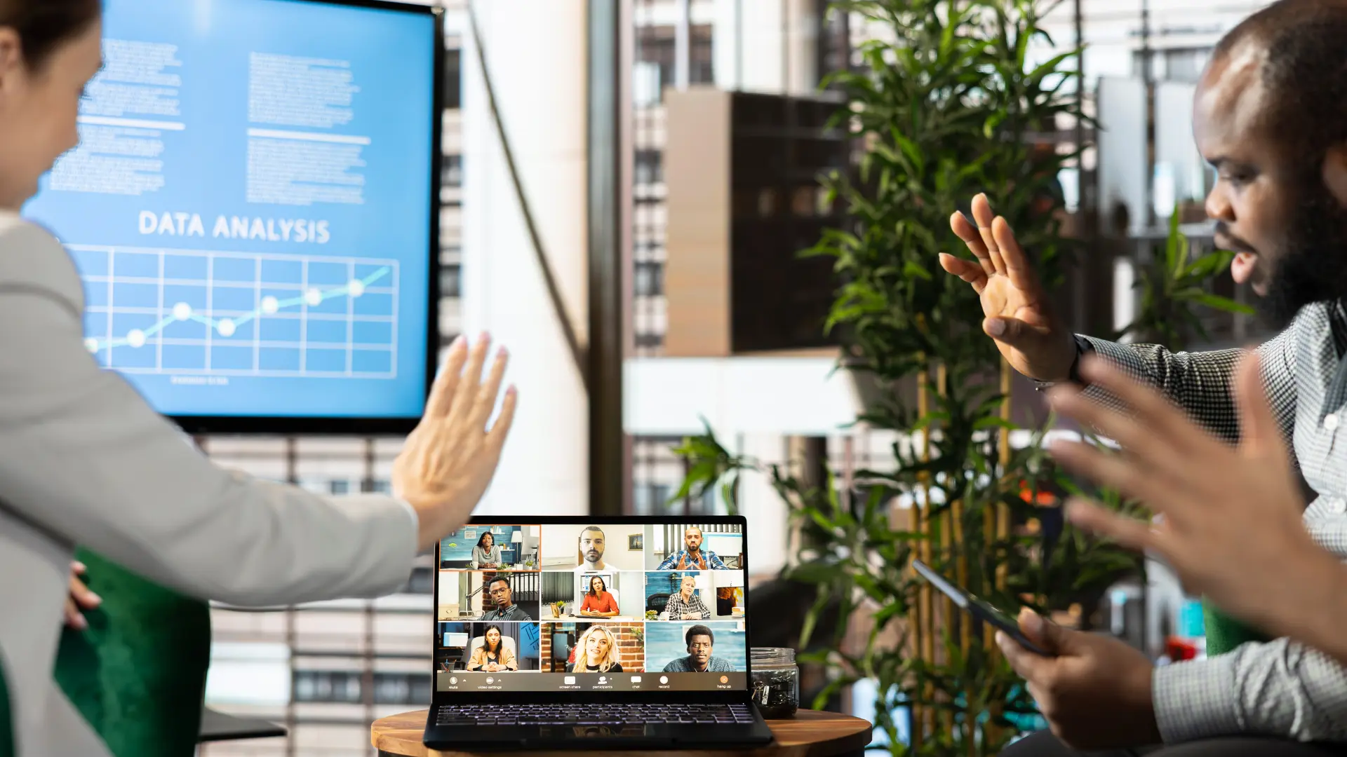 Professionals participating in a hybrid meeting with in-person collaboration and virtual attendees connected through video conferencing.