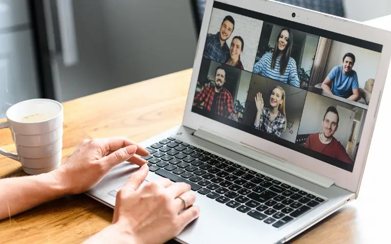 A person on a laptop joining a Zoom breakout room video call with a group of colleagues.