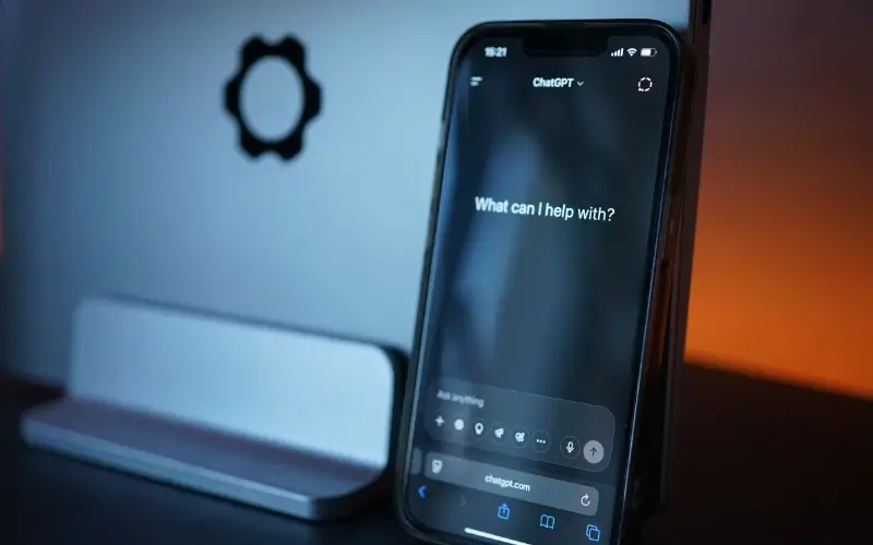 A smartphone resting on a stand displaying the ChatGPT application on screen.