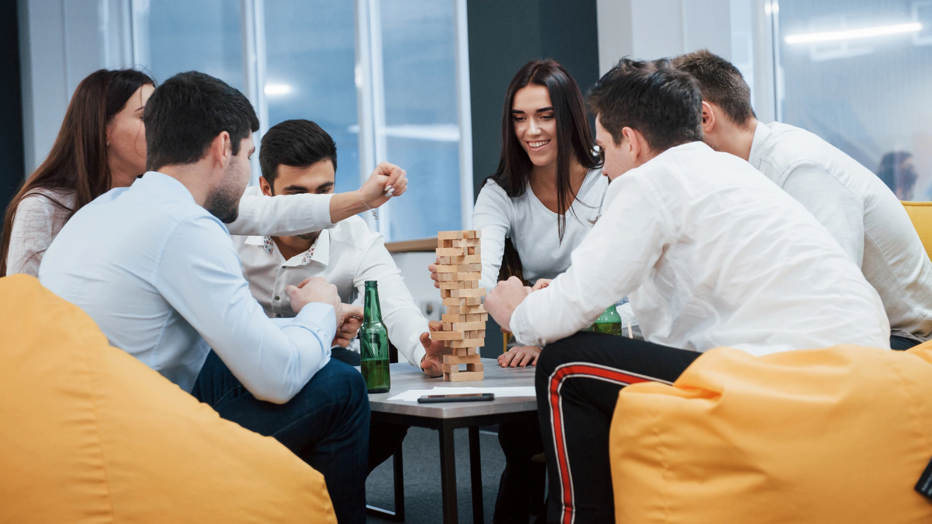 Professionals gathered around a table playing a team-building game during an interactive club meeting or networking session.