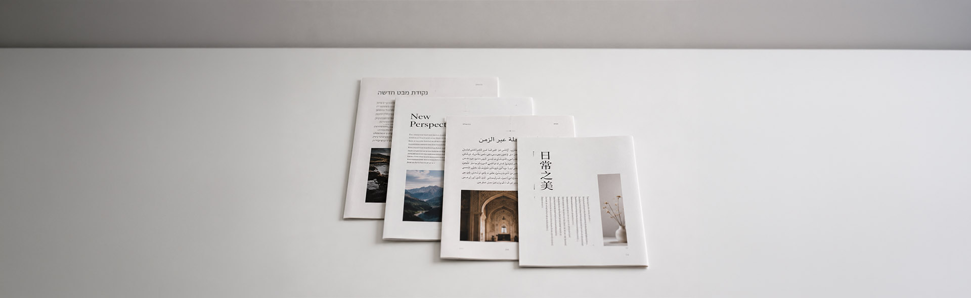 Four printed pages fanned out showing multilingual layouts in Arabic, Chinese, Hebrew, and Latin script — multilingual desktop publishing services