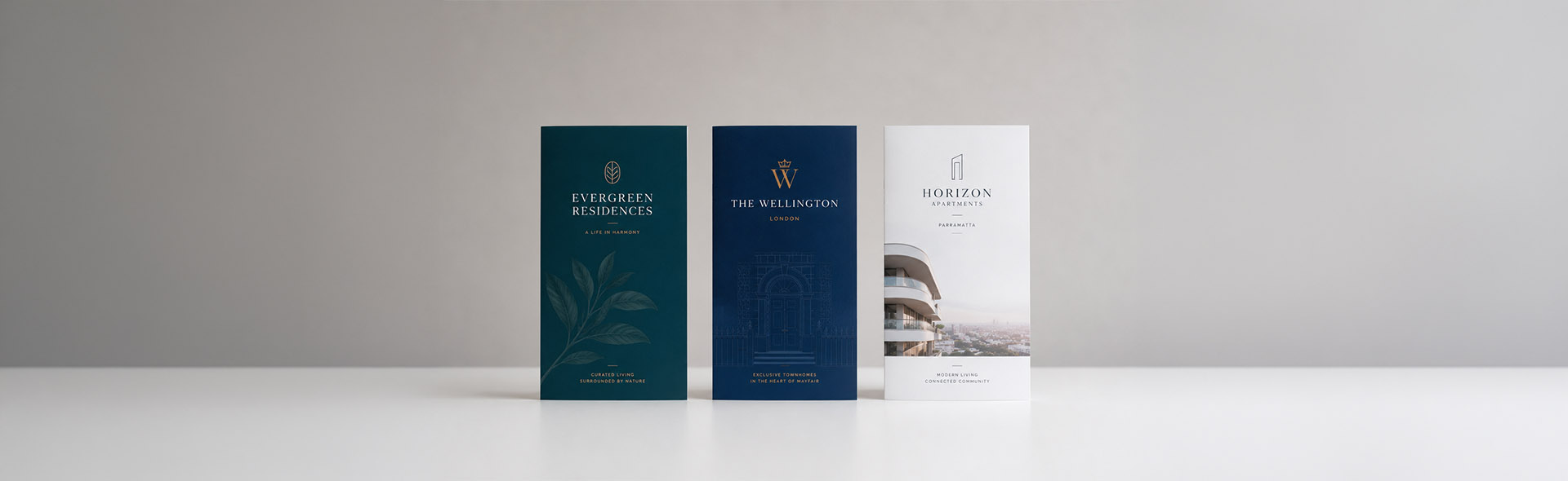 Three printed brochures standing upright on a white surface — professional brochure, flyer, and magazine design for print