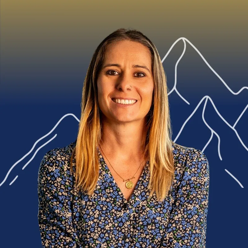 Femme souriante en robe fleurie bleue, devant des montagnes blanches tracées sur un fond bleu dégradé.