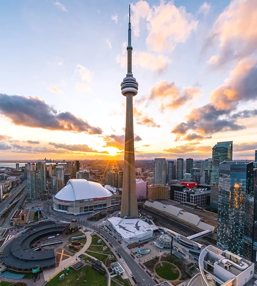 Smiling man with short hair wearing a white shirt and a light plaid blazer.