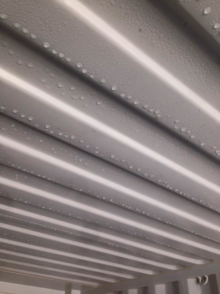 Photo of metal beams with droplets on them, viewed at an angle.