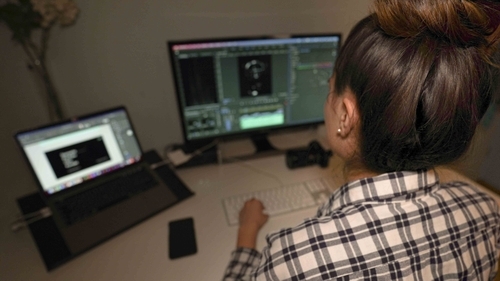 Post-Production: Multimedia Produzentin bearbeitet ein Video.