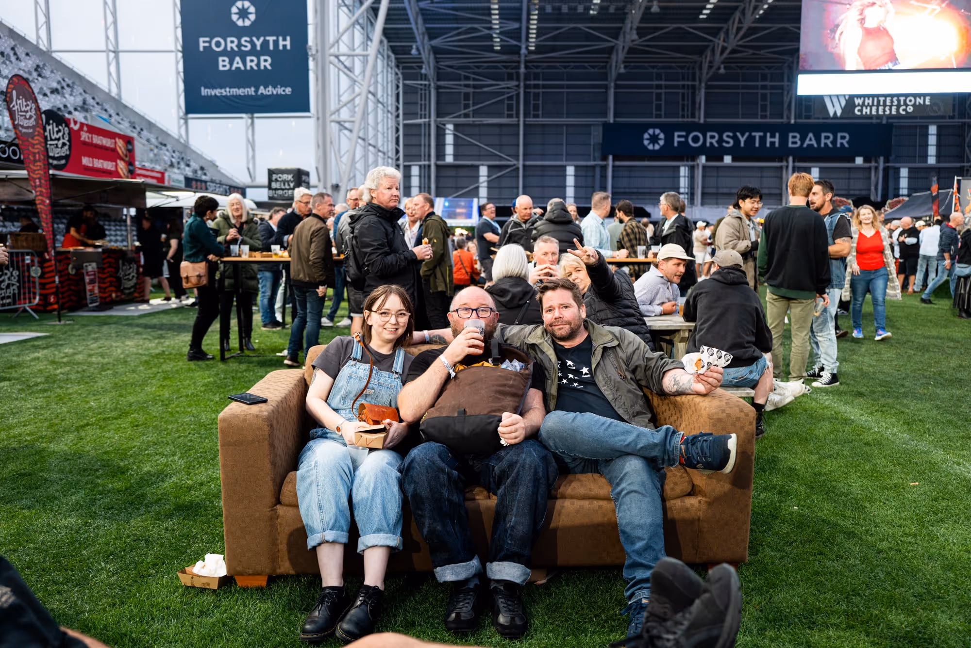 People sitting on a couch at the festival enjoying a beverage
