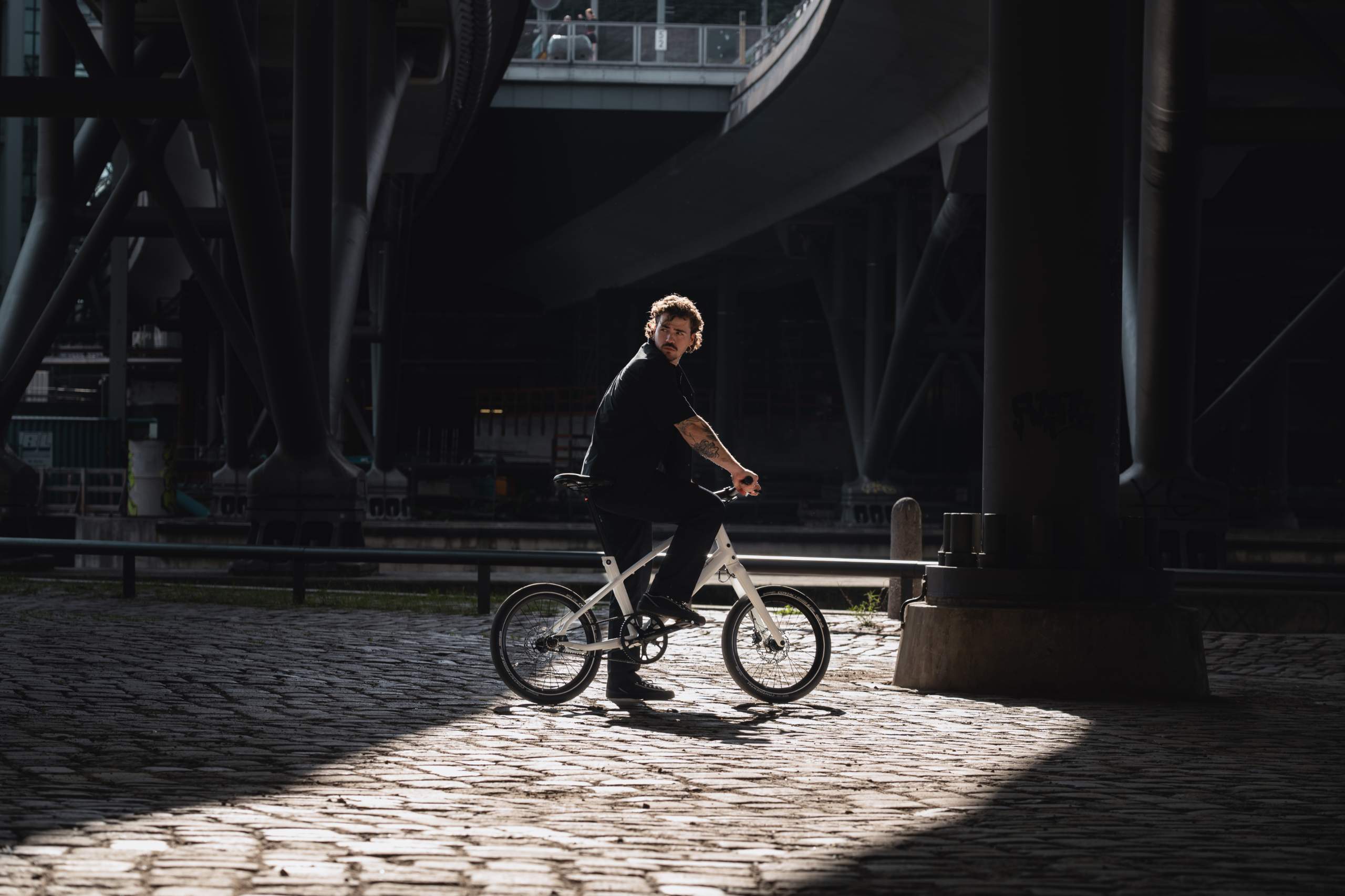 Bild von Mann auf Schindelhauer Neo in einer urbanen Umgebung, perfektes repräsentatives Stimmungsfoto für das Schindelhauer Neo Kompaktrad.