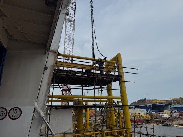 SAGA X's boat landing structure being lifted into position by crane.