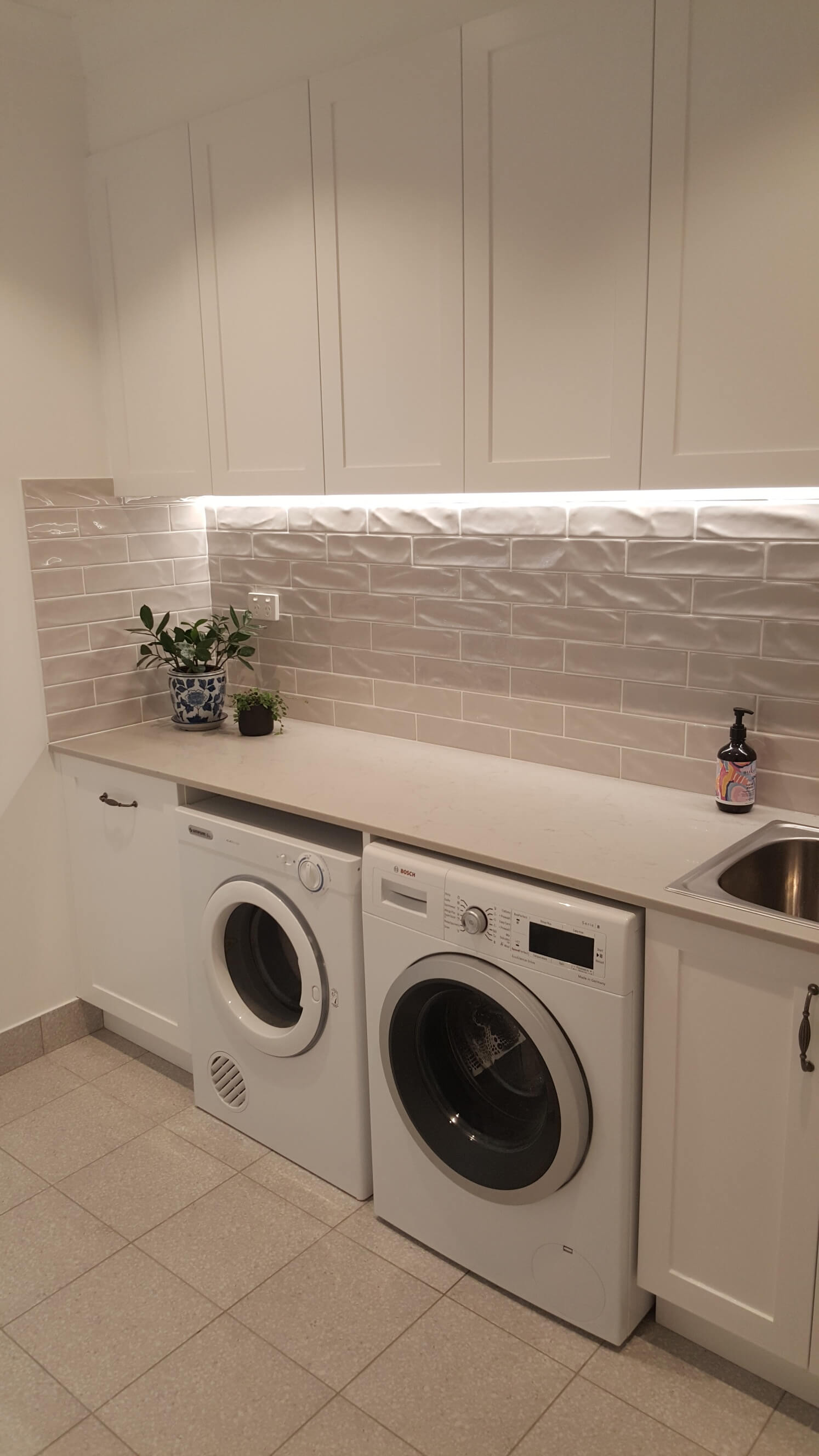 Modern laundry with built-in cabinetry and efficient layout