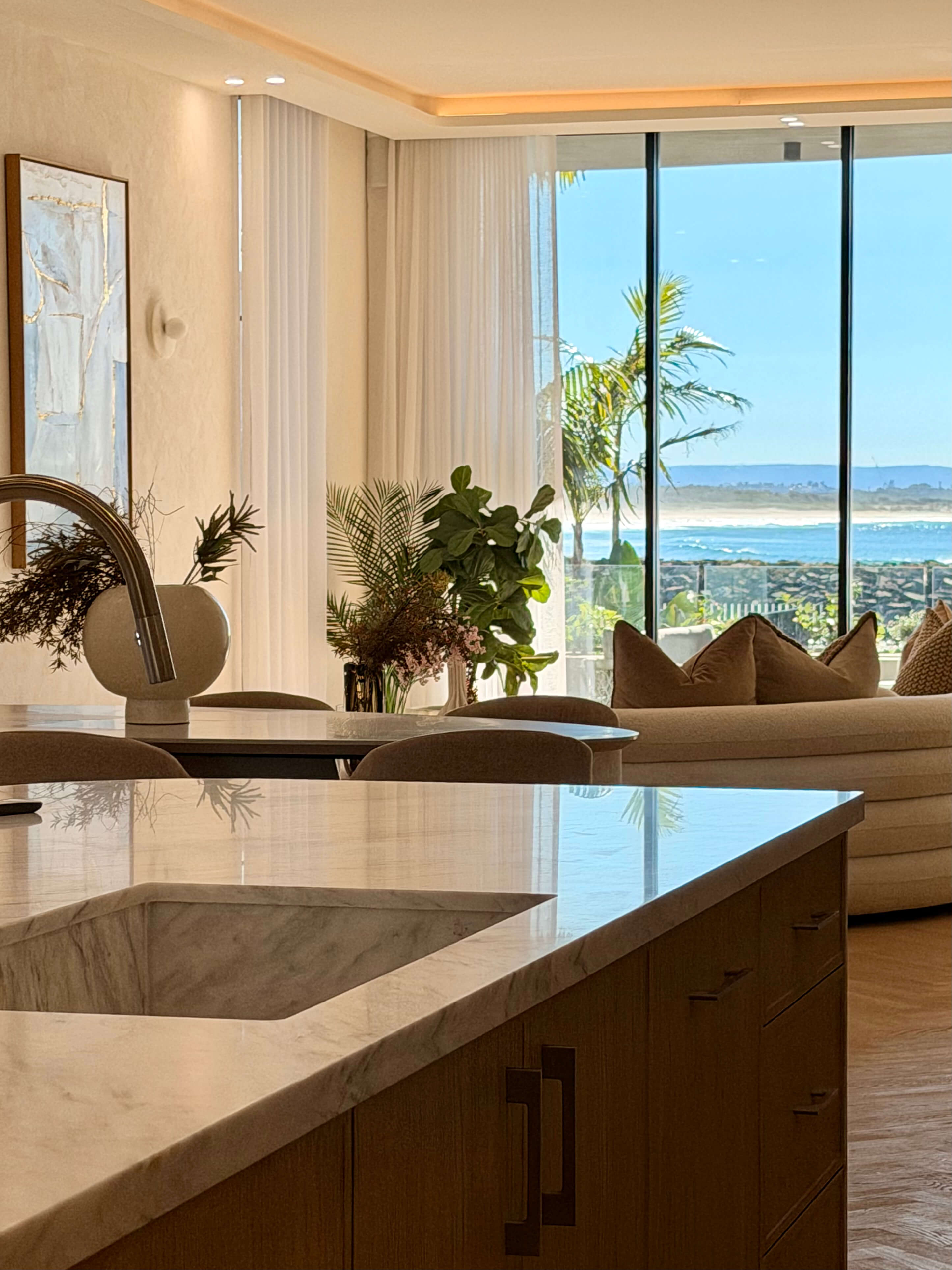 Custom coastal kitchen featuring natural stone benchtops, neutral cabinetry and stunning ocean views.