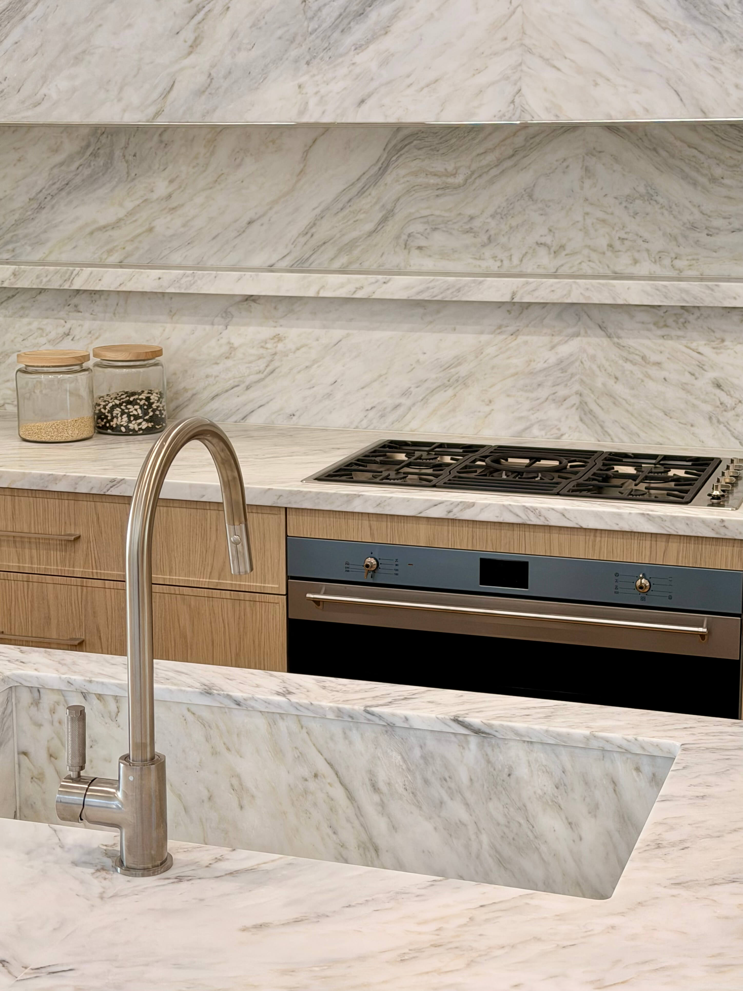 Custom luxury kitchen with natural stone benchtops, an integrated stone sink and premium bespoke joinery.