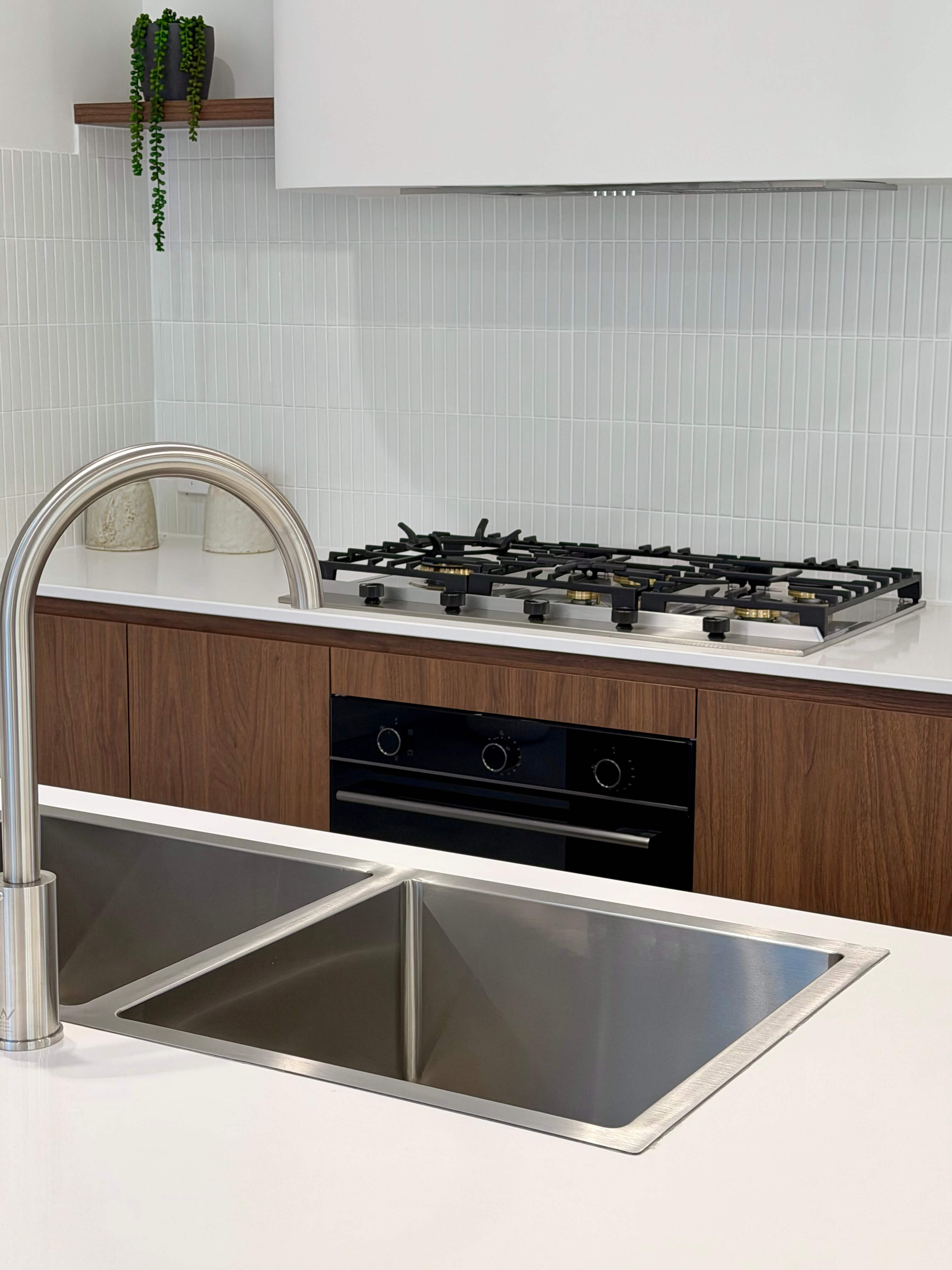 Modern kitchen showcasing a walnut timber island, natural stone benchtops and handcrafted custom cabinetry.