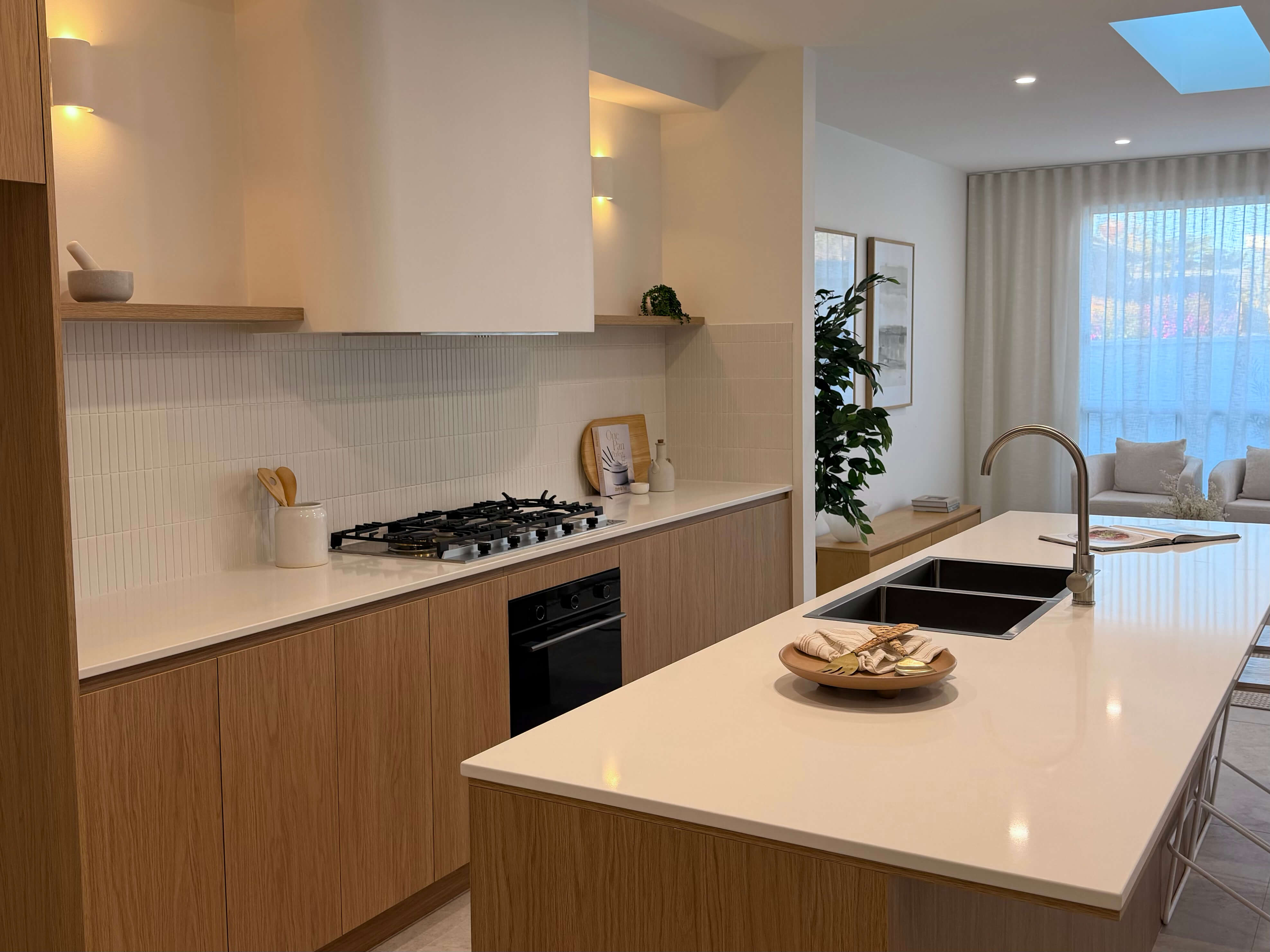 Custom kitchen featuring warm timber joinery, a natural stone island and bespoke cabinetry.