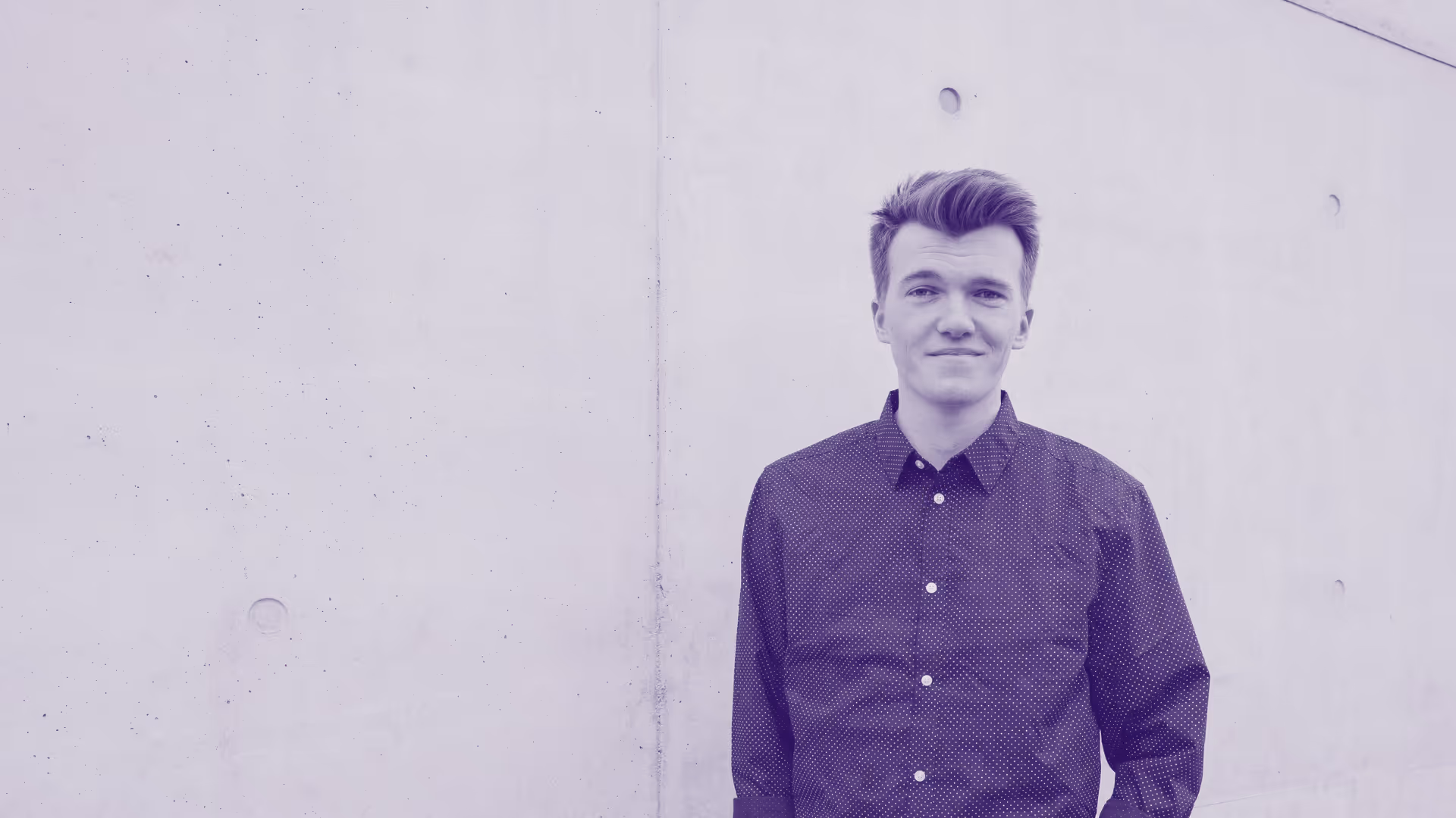 Mann steht vor Wand leicht angelehnt