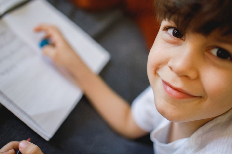 Teacher holds up a picture book to her class on a video call