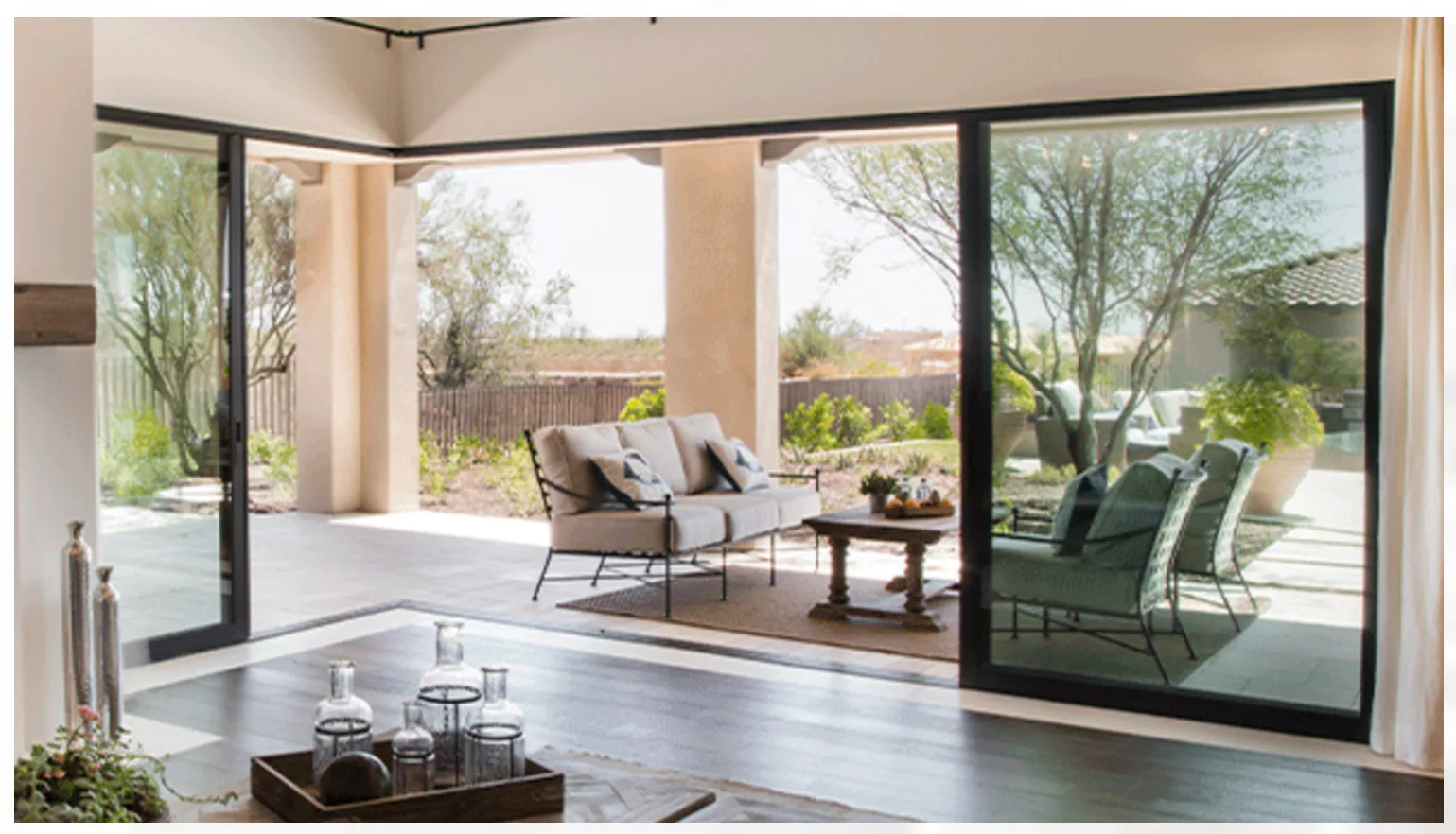 Image of Milgard's AX650 Moving Glass Walls Opening a Living Room up to a Backyard Lounge.