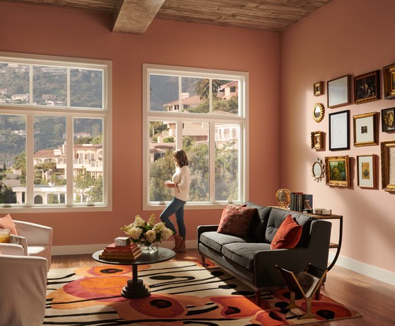 Image of a Woman in her Living Room Looking Out Retrofit Casement Windows