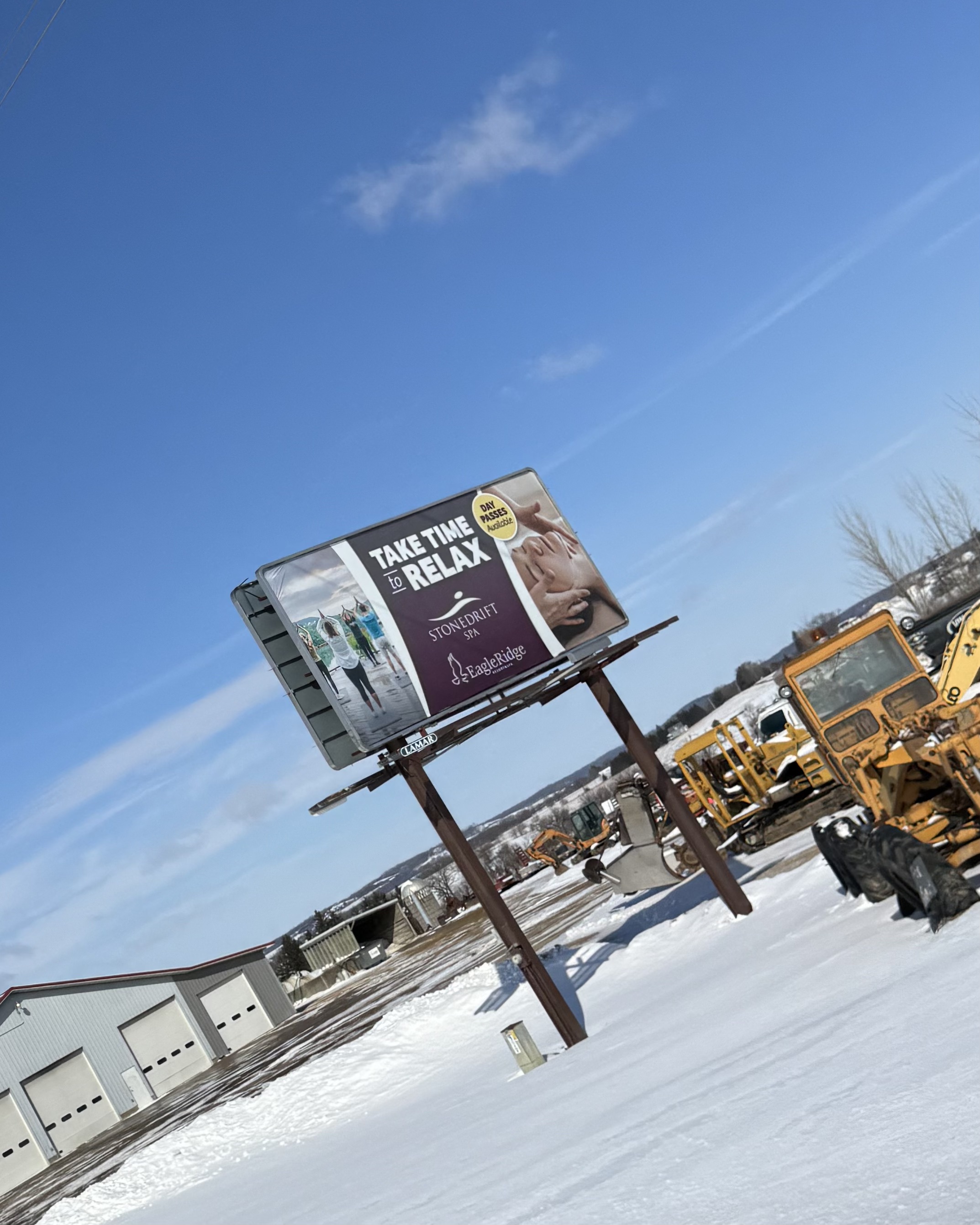 photograph of a billboard on the side of the road, with imagary by Skorynko Media Group of the activities by Stonedrift Spa at Eagle Ridge Resort
