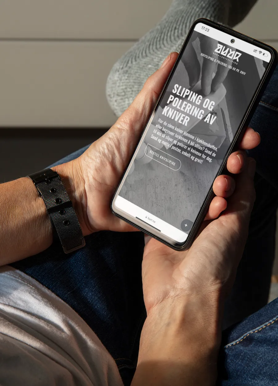 Bilde av mann som holder sin telefon. Nettside utviklet for BURR. Webdesigner på Øvre Romerike i Akershus, med base i Nannestad og Jessheim.