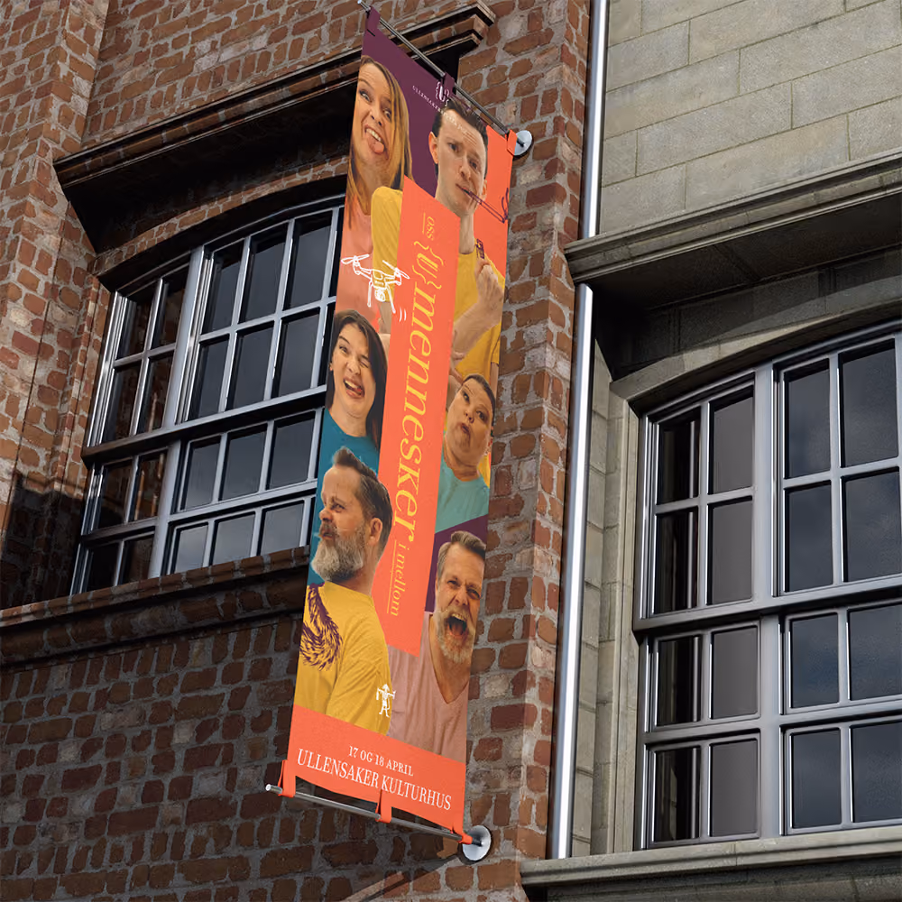 Hengende banner på murvegg med bilde av skuespillere som lager ulike grimaser. RåW studio, grafisk designer på Jessheim.
