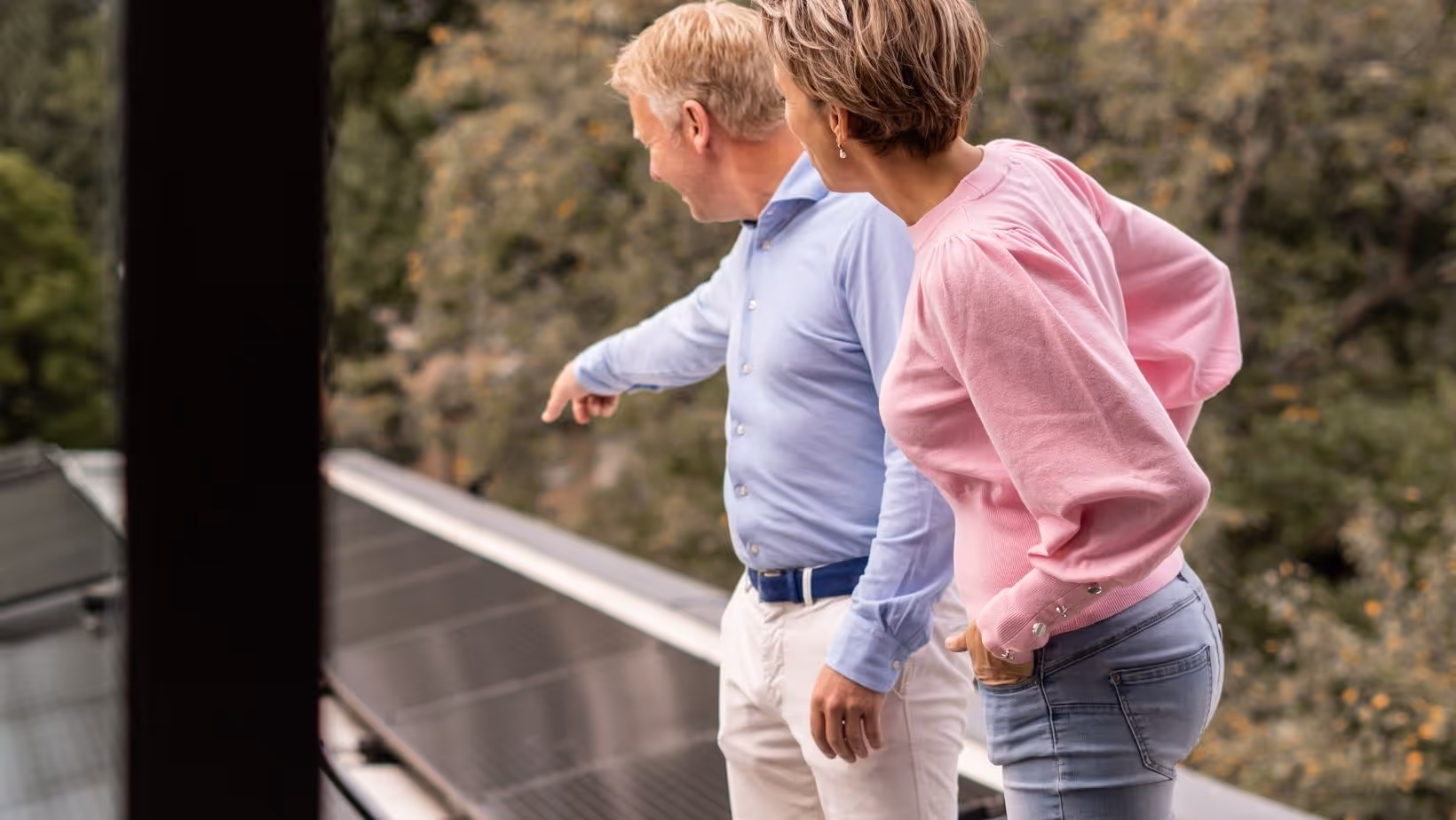 A man and woman pointing to solar panels