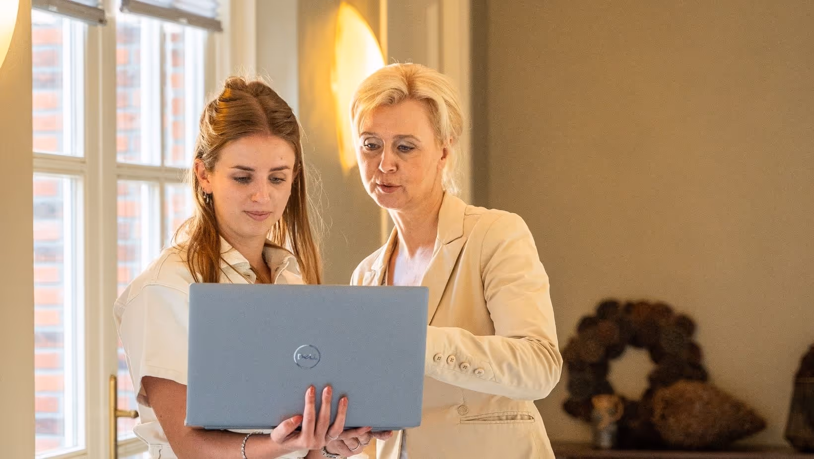 Twee dames staand achter een laptop