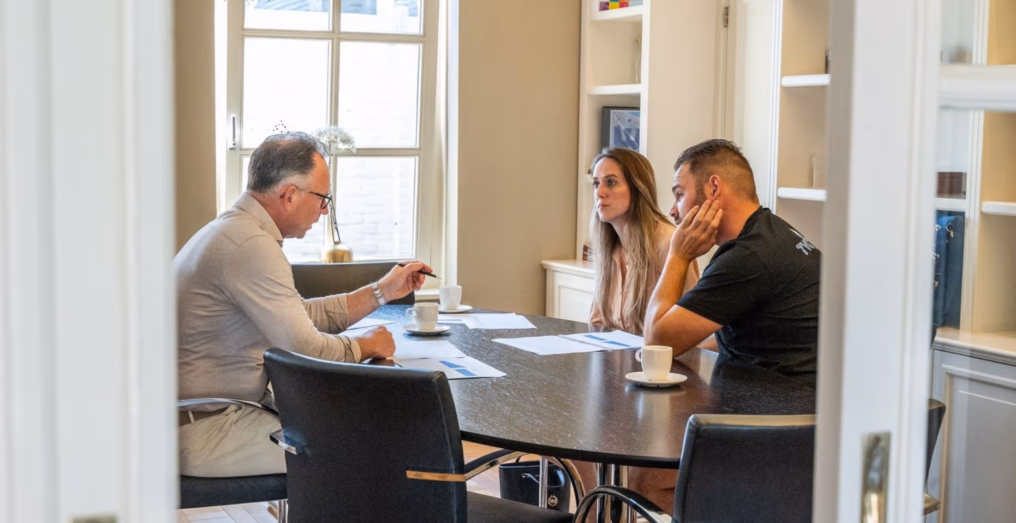 Klanten bij adviseur aan tafel