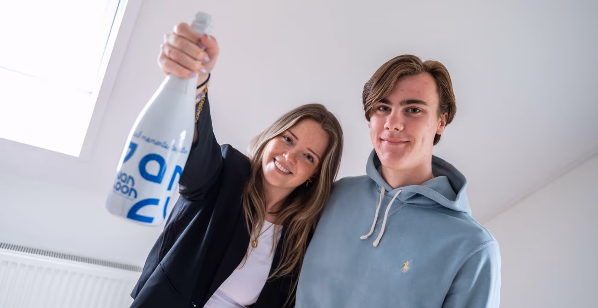 Man en vrouw in huis met fles champagne