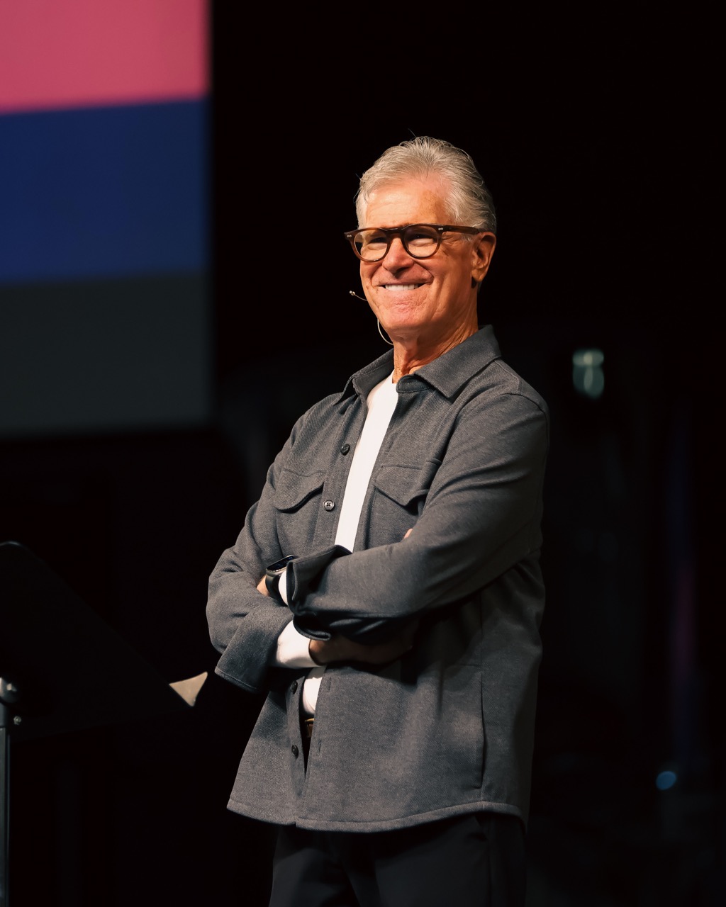 Emerson Eggerichs, PhD smiling with glasses and gray hair wearing a gray jacket, standing outdoors in front of a church building.