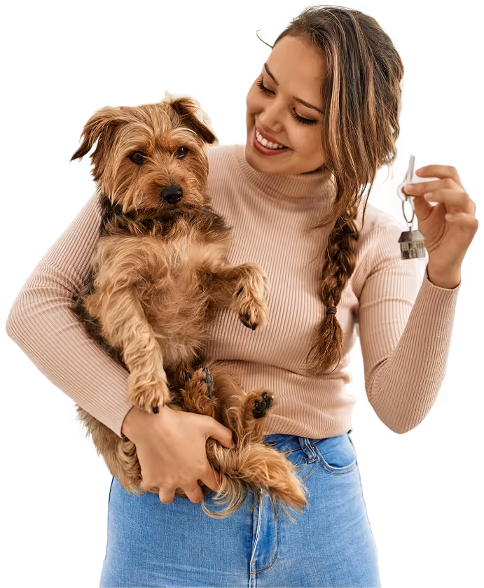 Smiling woman holding her dog outdoors during a community event.