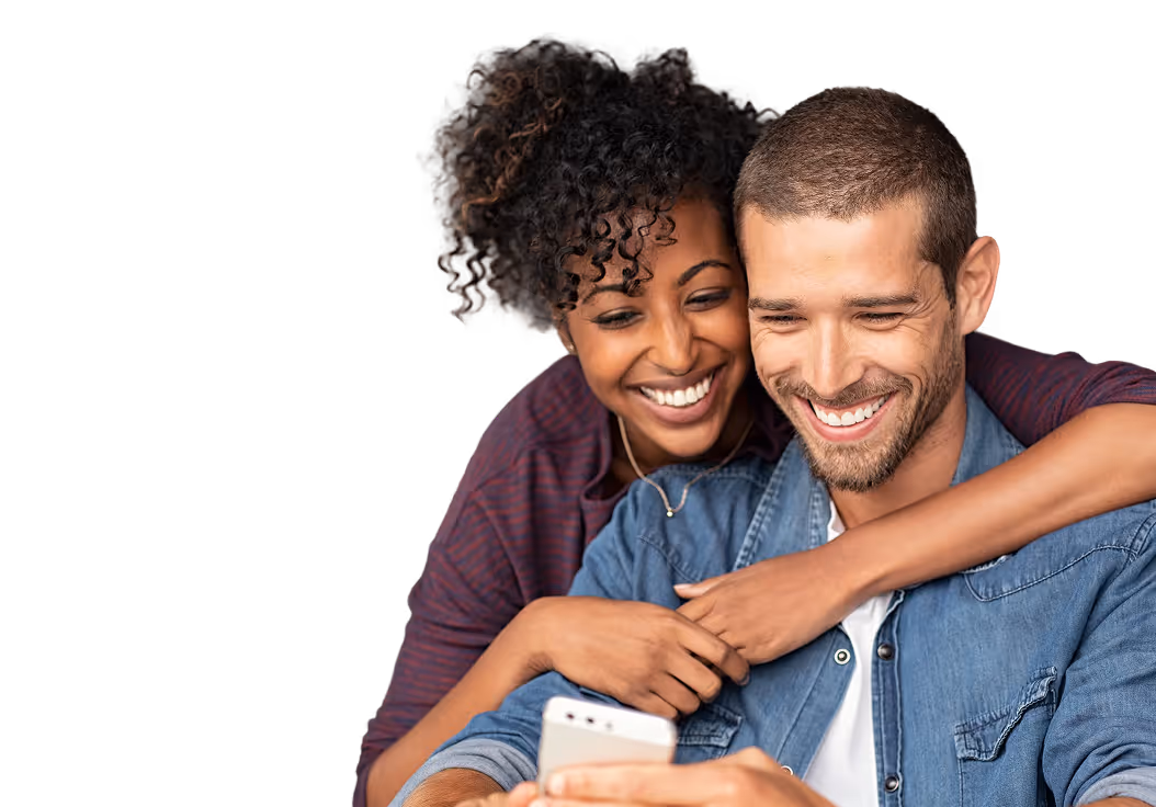 Happy couple relaxing together and smiling while using a mobile phone