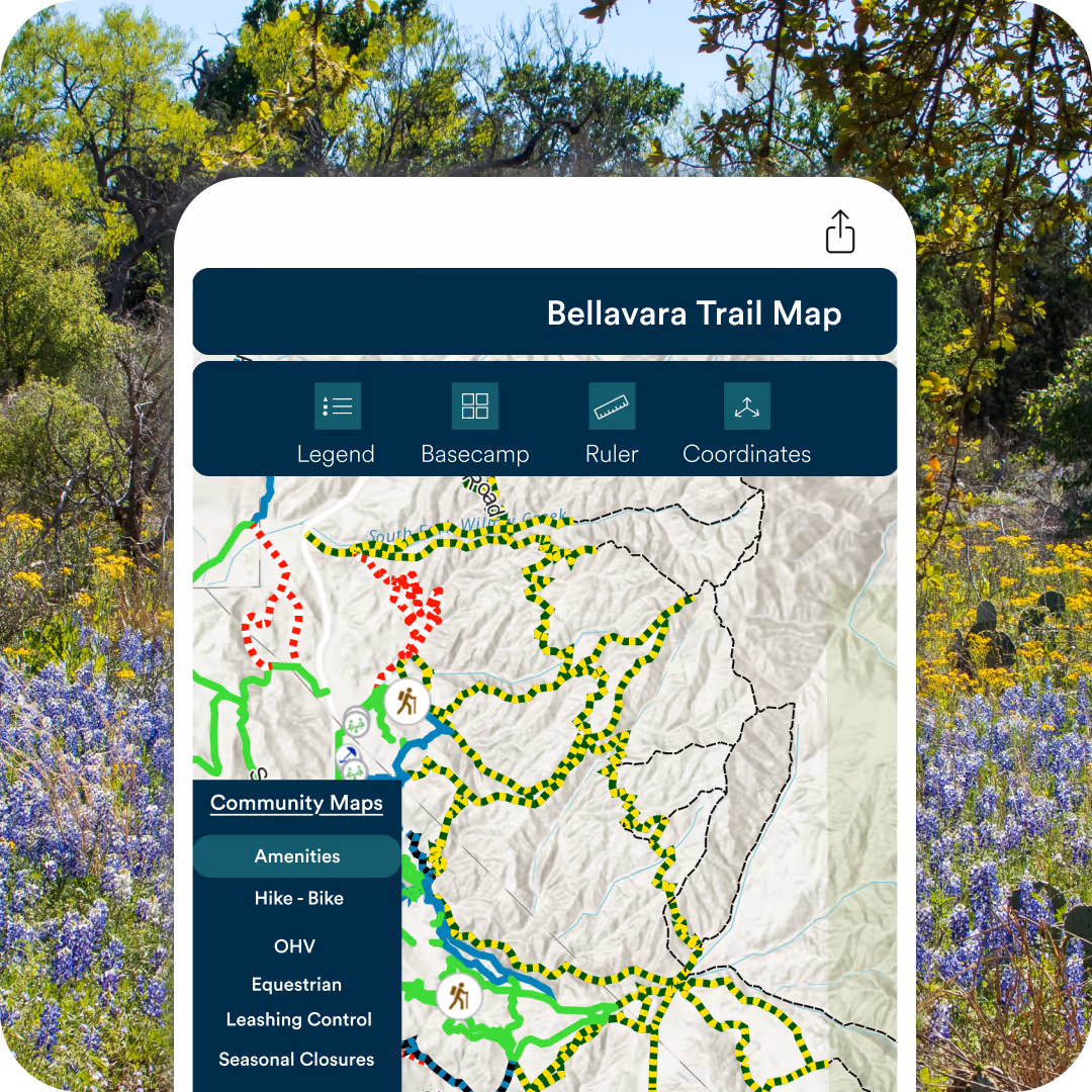 Smartphone screen showing Bellavara Trail Map with colorful trail routes and options menu on a background of wildflowers.