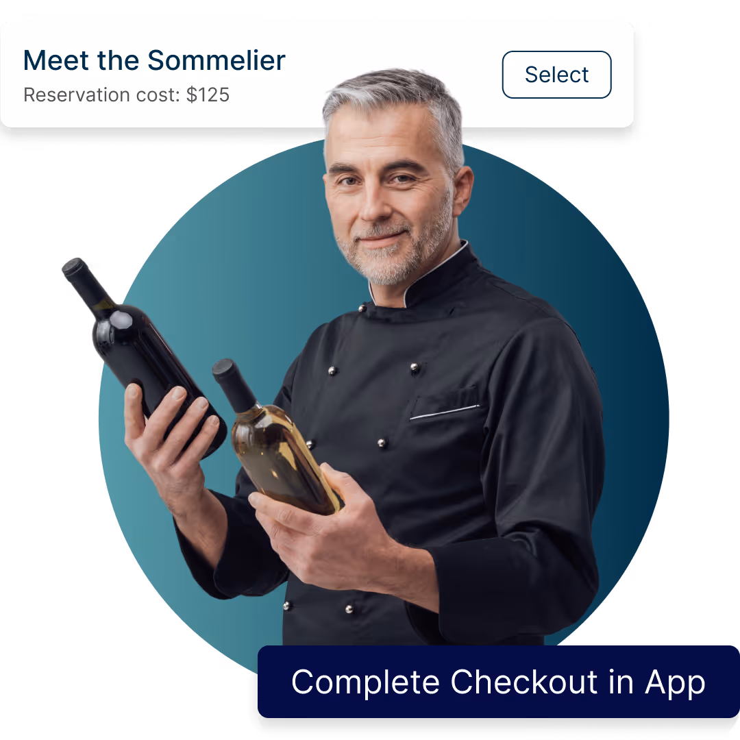 Middle-aged sommelier holding a bottle of red and white wine wearing a black chef jacket.