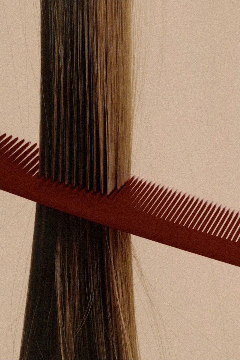A comb drawn through long dark hair, close up